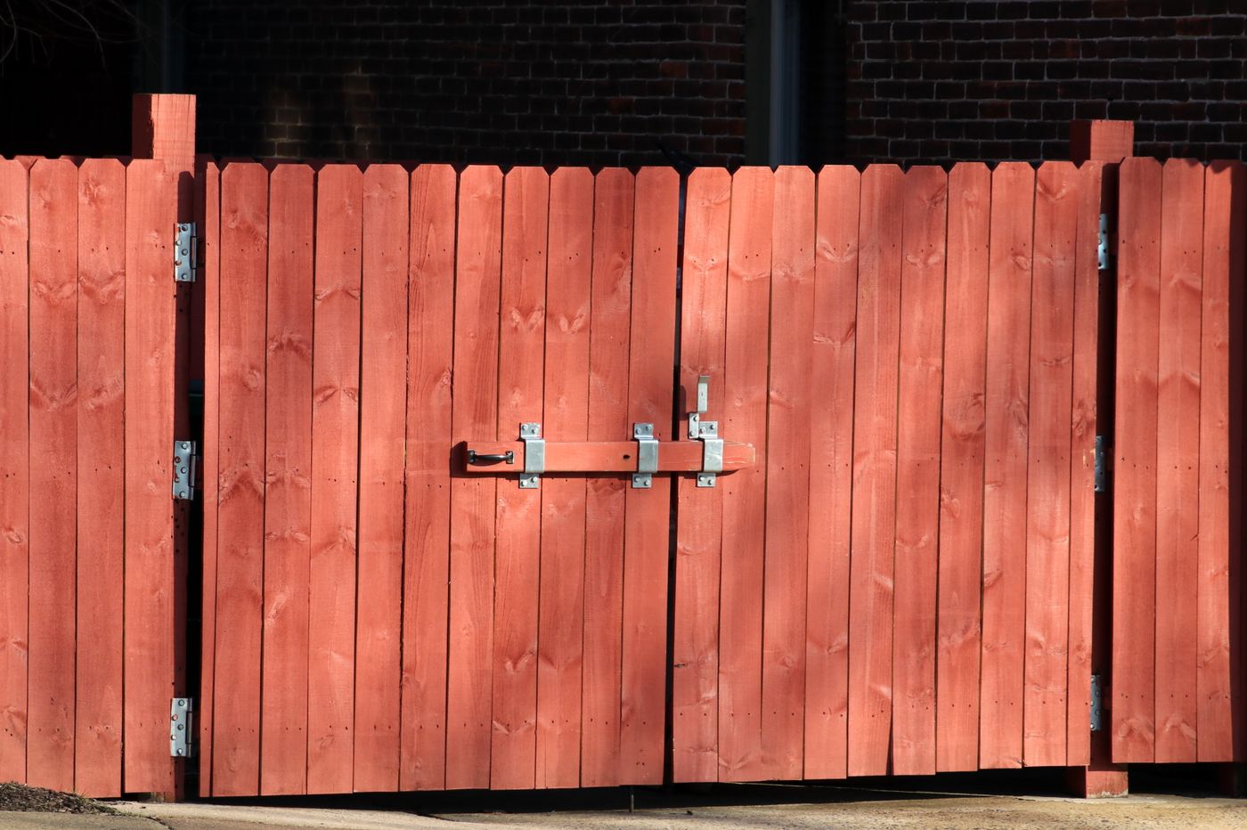 Wood privacy fence with double gate installed along a residential driveway